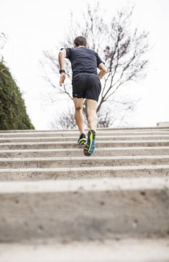 siyah runner merdiven arkadan tırmanıyor.