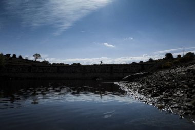 Göle yakın köprü üzerinde sürme bisikletçi