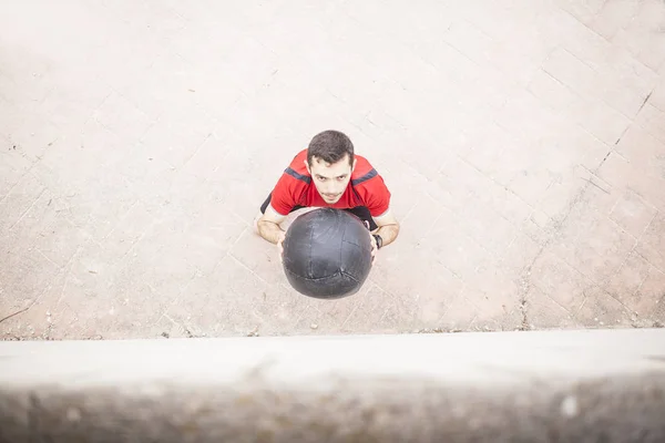 Man training with the medicine ball against the wall aerial vision — Stock Photo, Image
