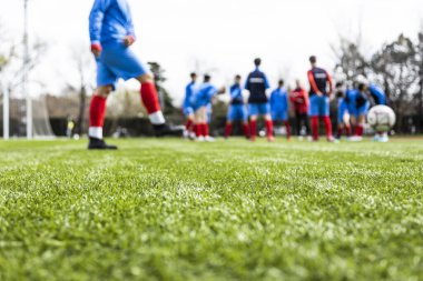 Genç ve tanınmayan futbol takımı oynamak için ısınma egzersizleri yapıyor. Odaklanamayan bir bakış açısı..