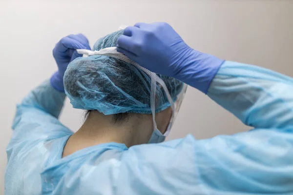 Unrecognizable Young Nurse Tying Her Respirator Protective Clothing — Stock Photo, Image