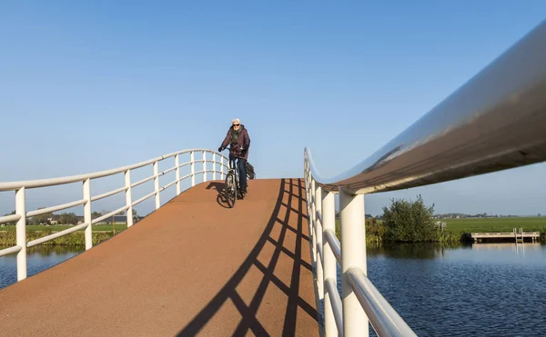 Ciclista donna sul ponte Groot-Ammers — Foto Stock