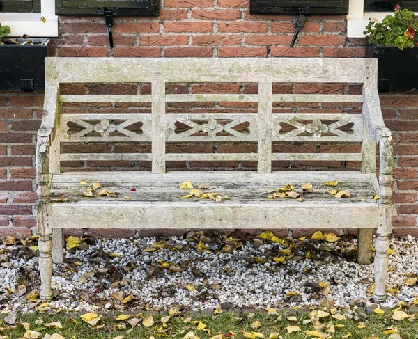 Panca da giardino con foglie — Foto Stock