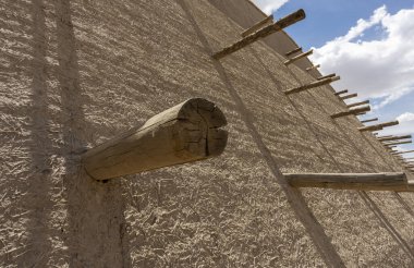 Özbekistan 'ın eski Khiva kasabasının ortasında kirişleri olan büyük duvar..