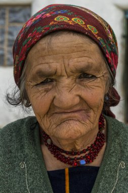 Wakhan, Tajikistan - June 20, 2020: Portrait of an old woman in traditional clothes in the Wakhan Valley at the Pamir Highway in Tajikistan.