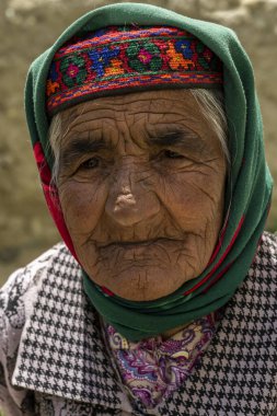 Wakhan, Tajikistan - June 20, 2020: Portrait of an old woman in traditional clothes in the Wakhan Valley at the Pamir Highway in Tajikistan.