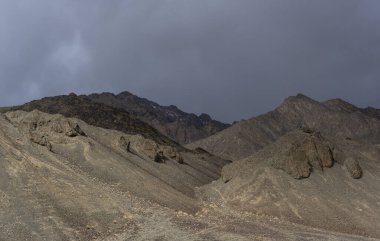 Murghab Nehri Vadisi 'ndeki çıplak dağ. Pamir Otoyolu' ndaki Tacikistan 'ın Murghab köyü yakınlarında kara yağmur bulutları var..