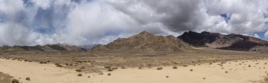 Murghab Vadisi 'ndeki çıplak dağ panoraması. Pamir Otoyolu' ndaki Murghab, Tacikistan köyü yakınlarında kara yağmur bulutları var..