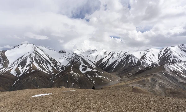 タジキスタン アックバイタル峠2019年6月26日 雪の多い高い山と谷を望むアックバイタル峠の山の上の男 — ストック写真