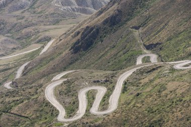 Dağlarla dolu bir yaz gününde Kırgızistan Vadisi ile Toguz Toro Geçidi 'nde toprak yol.