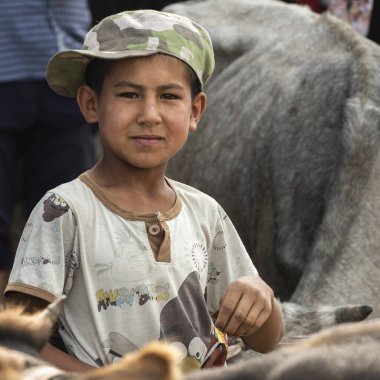 Osh, Kırgızistan - 30 Haziran 2019: Osh, Kırgızistan 'da koyun ve keçiler arasındaki çiftlik hayvanları pazarında çocuk.
