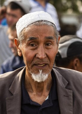 Osh, Kırgızistan - 30 Haziran 2019: Osh, Kırgızistan 'da hayvan pazarında şapkalı bir adam.