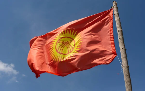 吉尔吉斯斯坦的国旗在山谷中飘扬 在夏日的群山中飘扬 天空蔚蓝 — 图库照片