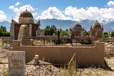 Kochkor, Kırgızistan - 8 Temmuz 2019: Kırgızistan 'daki Kochkor' da dağlı ve karlı bir yaz gününde büyük, eski, İslami mezarlı bir mezarlık.