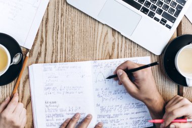 Üstten Görünüm defterini, kitap ve dizüstü bilgisayar ile insan. Kahve Tablo