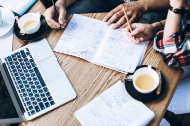 Üstten Görünüm defterini, kitap ve dizüstü bilgisayar ile insan. Kahve Tablo