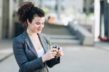 Kiev, Ukrayna - 21 Temmuz 2017: İş kadın plaing Rubik küpü ile. Rubik küpü bir Macar mimar tarafından Erno Rubik 1974 yılında icat.