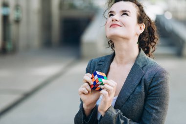Kiev, Ukrayna - 21 Temmuz 2017: İş kadın plaing Rubik küpü ile. Rubik küpü bir Macar mimar tarafından Erno Rubik 1974 yılında icat.