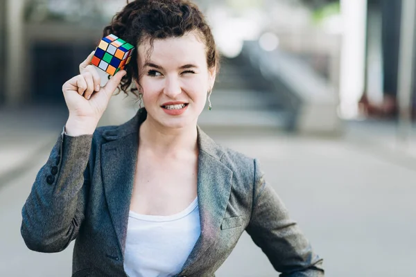 Kiev, Ucrânia - 21 de julho de 2017: Mulher de negócios entranhando com o Cubo de Rubik. Cubo de Rubik inventado por um arquiteto húngaro Erno Rubik em 1974 . — Fotografia de Stock