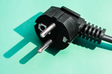 Gölge yeşil zemin üzerine elektrik fişi