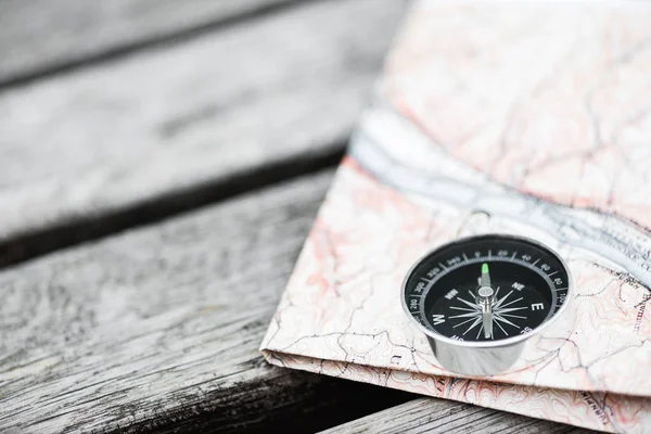 Compass and map on a beautiful wooden surface. Top view