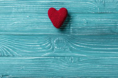 Örgü kalp mavi ahşap arka plan üzerinde