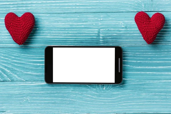 Smartphone avec écran blanc et coeur tricoté sur un beau fond en bois bleu. Concept de Saint-Valentin — Photo
