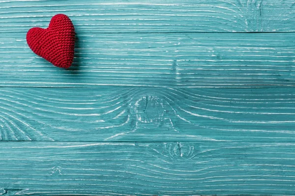 Вязанное сердце на синем деревянном фоне — стоковое фото