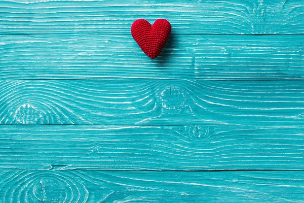 Örgü kalp mavi ahşap arka plan üzerinde