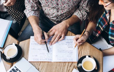 Üstten Görünüm defterini, kitap ve dizüstü bilgisayar ile insan. Kahve Tablo
