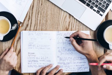 Üstten Görünüm defterini, kitap ve dizüstü bilgisayar ile insan. Kahve Tablo