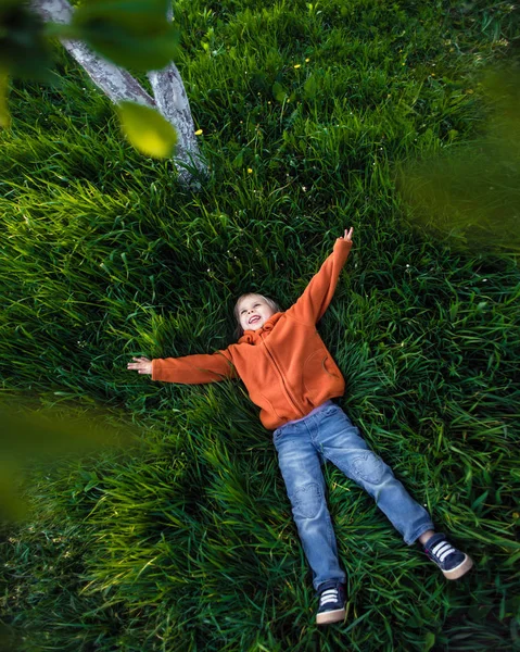 Criança feliz brincando na grama — Fotografia de Stock