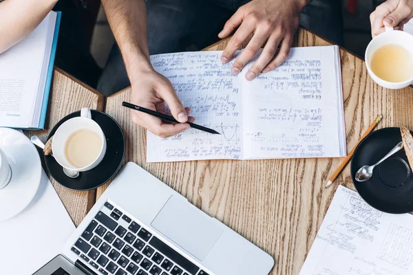 Visão superior das pessoas que estudam com livro, livro e laptop. Copos de café na mesa — Fotografia de Stock