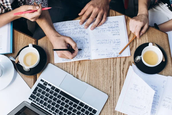 Visão superior das pessoas que estudam com livro, livro e laptop. Copos de café na mesa — Fotografia de Stock