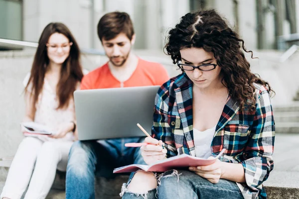 Gençler akıllı araçları kullanma ve okurken gülümseyen