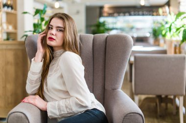 Profesyonel makyaj ve saç modeli restoranda oturan güzel genç kızla.