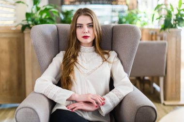 Profesyonel makyaj ve saç modeli restoranda oturan güzel genç kızla.