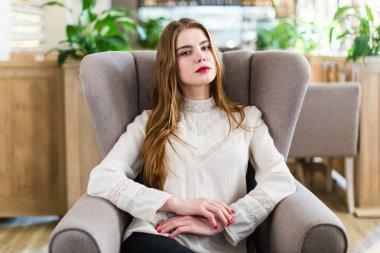 Profesyonel makyaj ve saç modeli restoranda oturan güzel genç kızla.