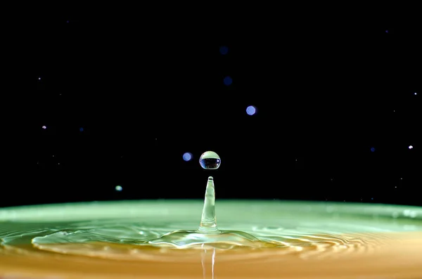 The water drop with interesting colorful blurred background — Stock Photo, Image