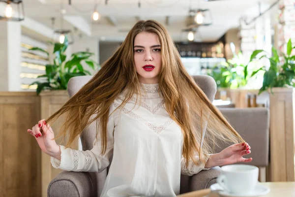 Hermosa joven con maquillaje profesional y peinado sentado en el restaurante . — Foto de Stock