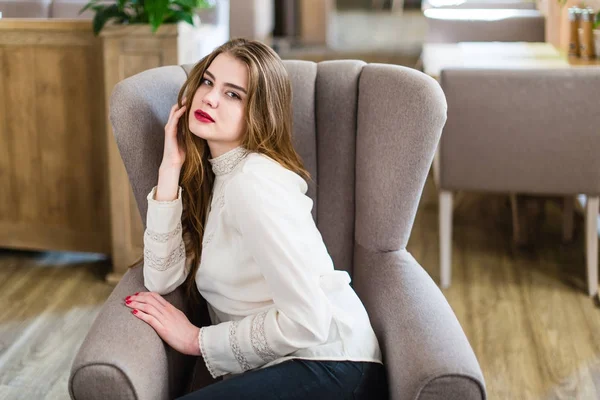 Profesyonel makyaj ve saç modeli restoranda oturan güzel genç kızla.