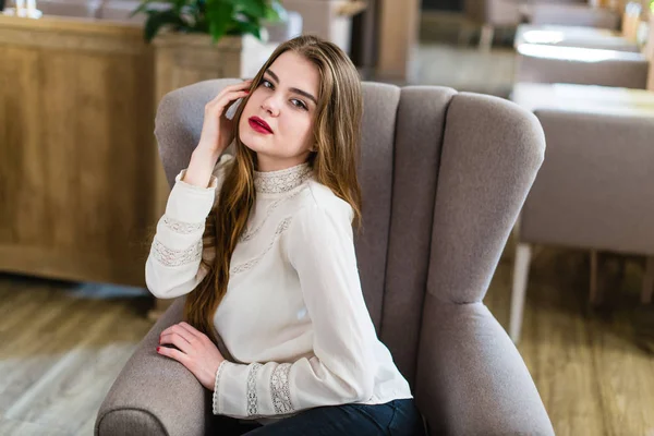 Profesyonel makyaj ve saç modeli restoranda oturan güzel genç kızla.