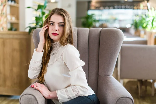 Profesyonel makyaj ve saç modeli restoranda oturan güzel genç kızla.