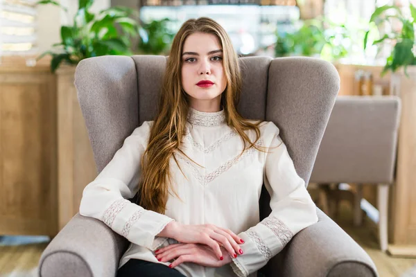 Profesyonel makyaj ve saç modeli restoranda oturan güzel genç kızla.