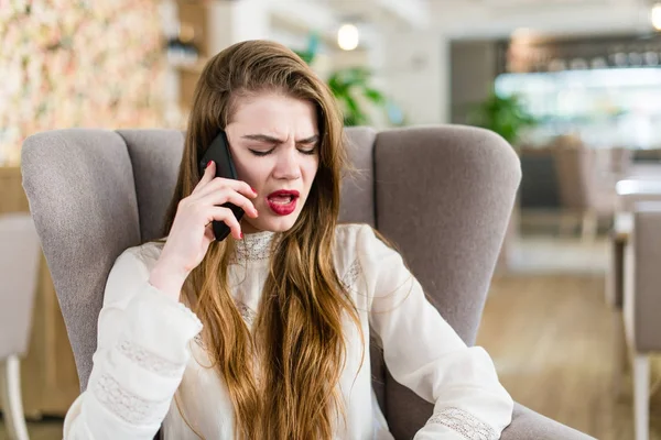 Красивая девушка в кафе разговаривает по мобильному телефону — стоковое фото