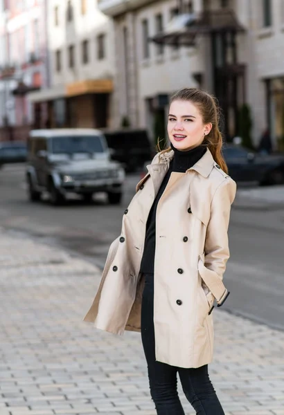 Hermosa chica de moda caminando por la ciudad en un abrigo — Foto de Stock