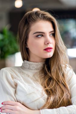 Profesyonel makyaj ve saç modeli restoranda oturan güzel genç kızla.