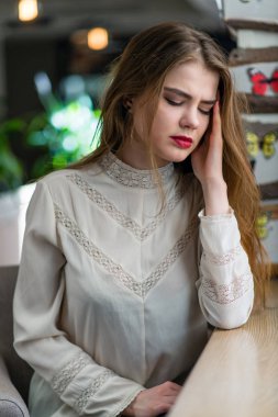 Profesyonel makyaj ve saç modeli restoranda oturan güzel genç kızla.