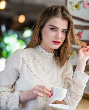 Profesyonel makyaj ve saç modeli restoranda oturan güzel genç kızla.