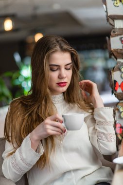 Profesyonel makyaj ve saç modeli restoranda oturan güzel genç kızla.